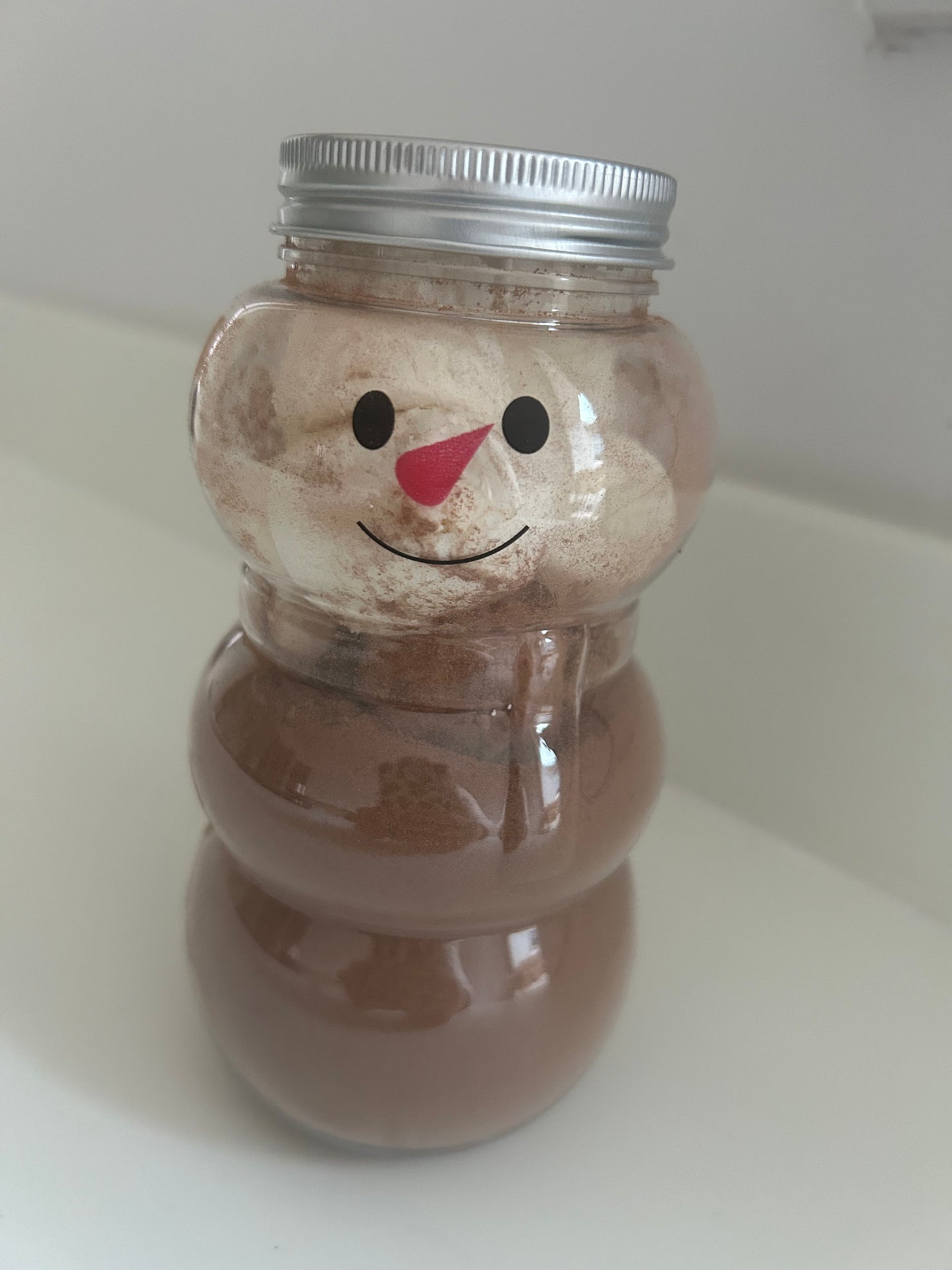 Snowman drinking jar filled with hot chocolate and marshmallows